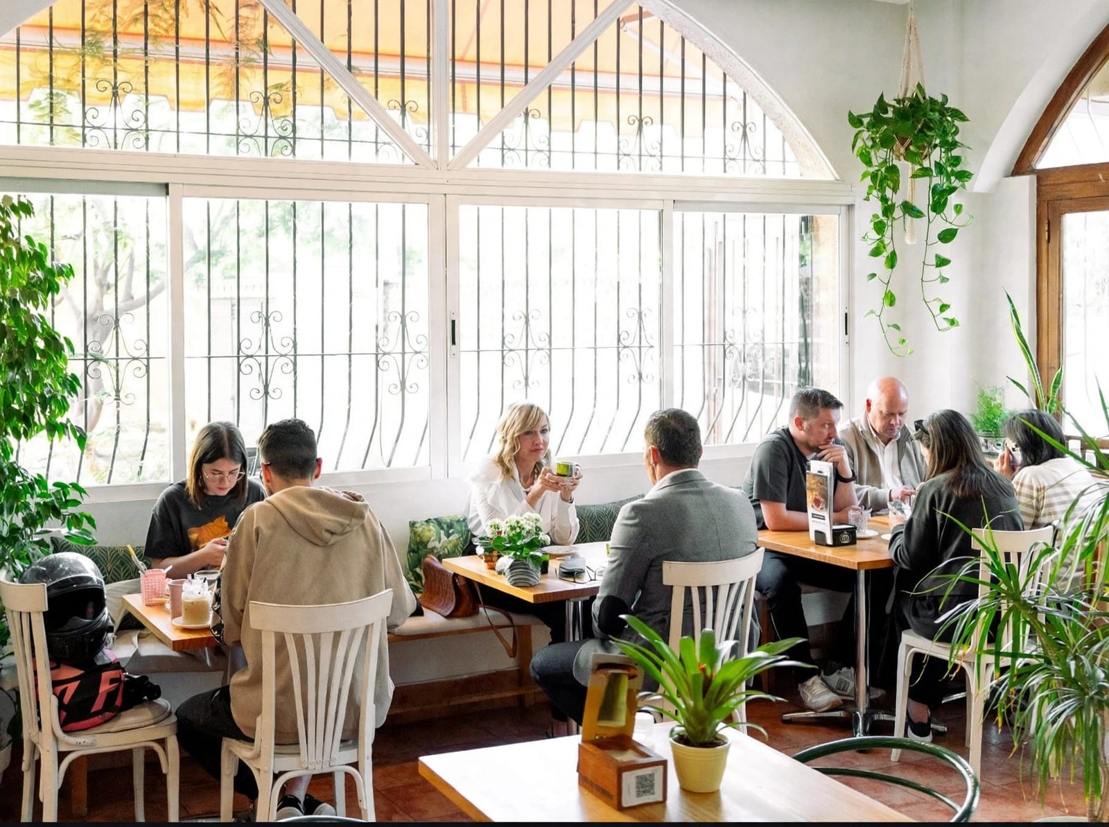 Imagen de referencia, creada con IA, de clientes en una sala luminosa con plantas